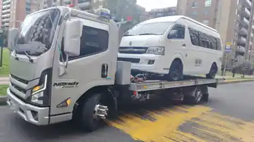Grúa real de NOVA transportando una van blanca